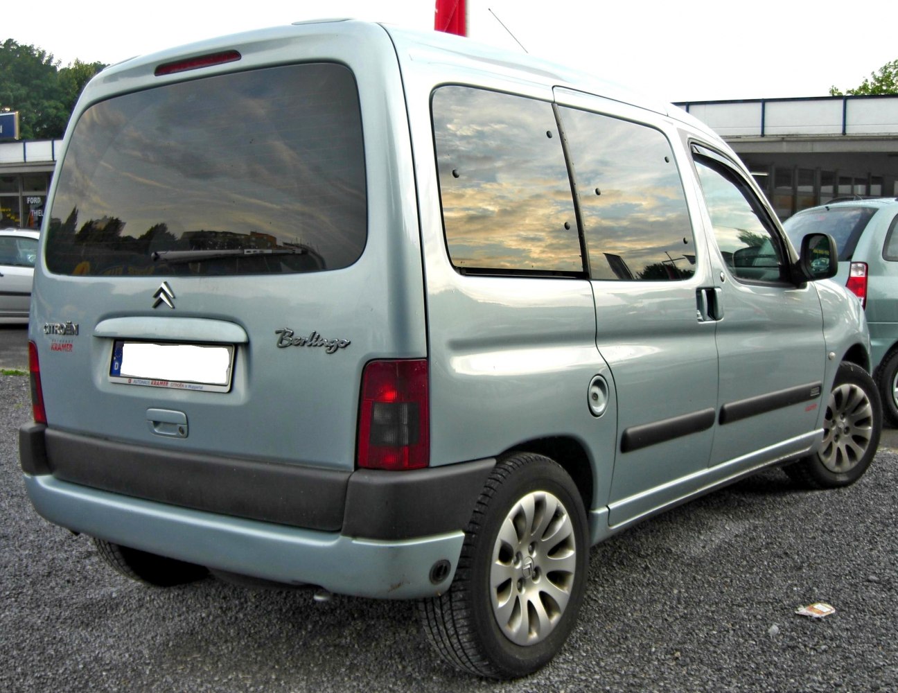 Rear and side view of a multi-purpose vehicle with distinctive windows and rear door
