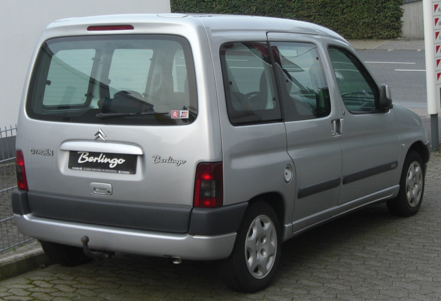 Silver vehicle rear-side with sliding door and large rear window