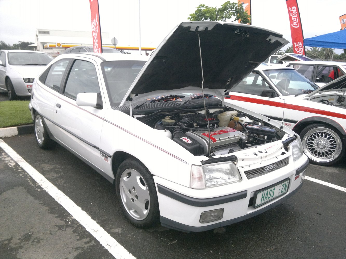 White hatchback with open hood showing engine bay details