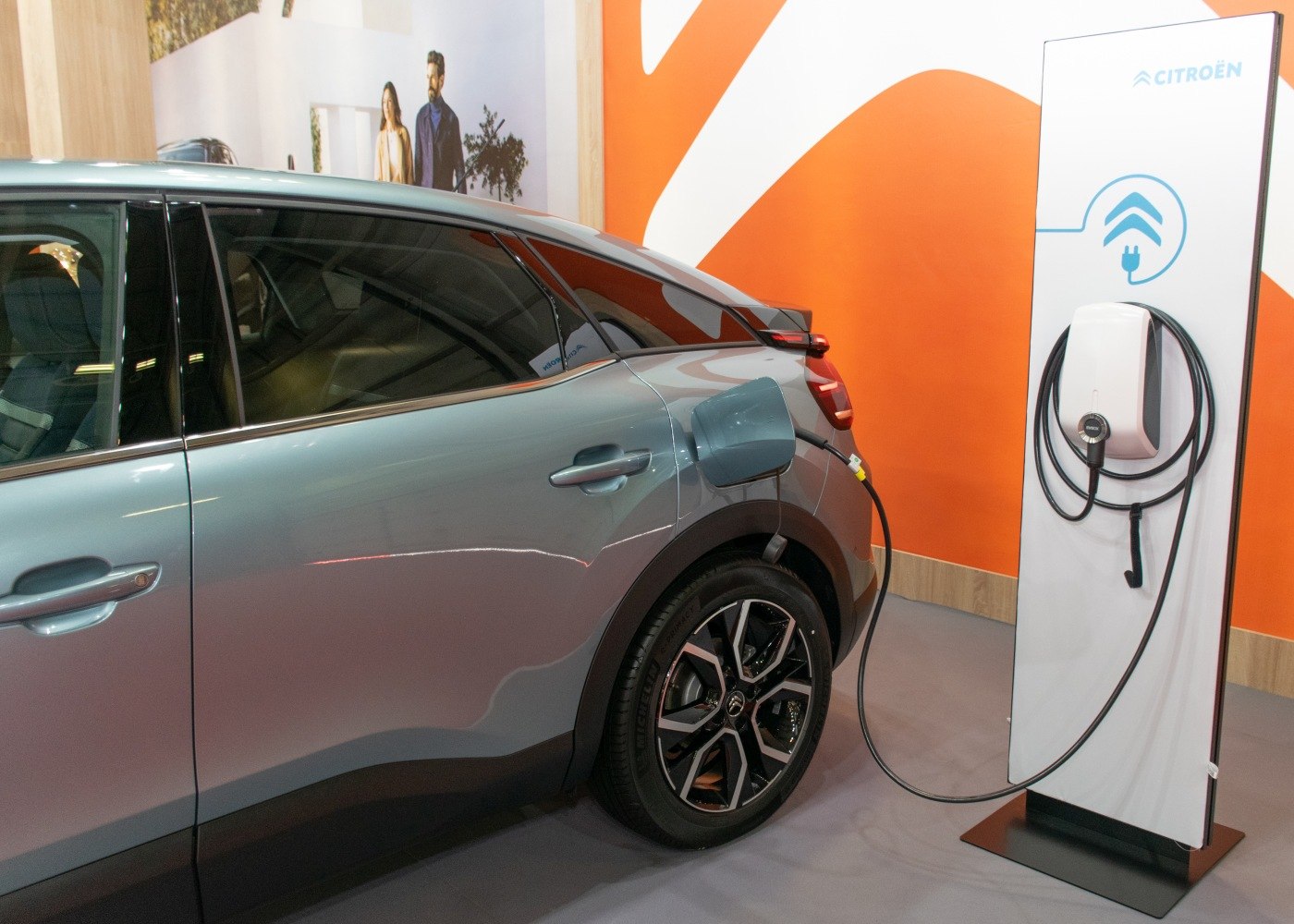 Electric charging port connected to charger on rear side of modern vehicle