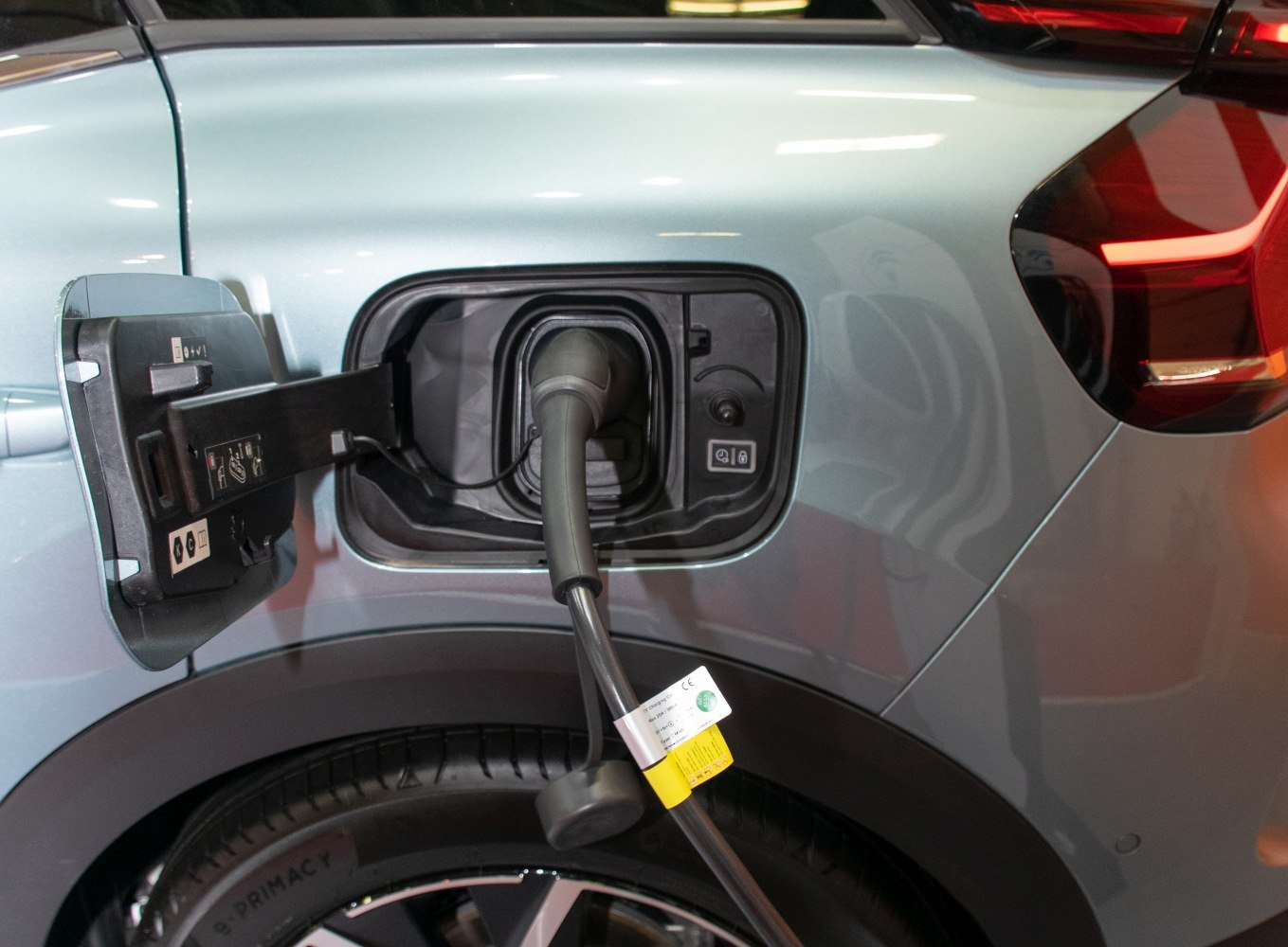 Electric charging port with cable connected on rear side near tail light.