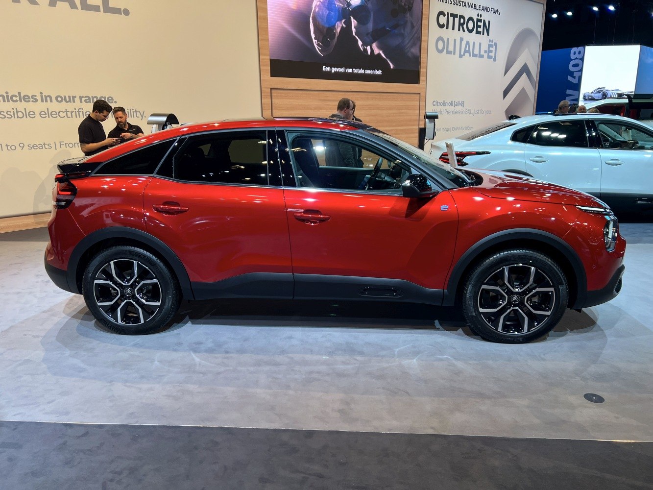 Side profile of red electric hatchback with black alloy wheels