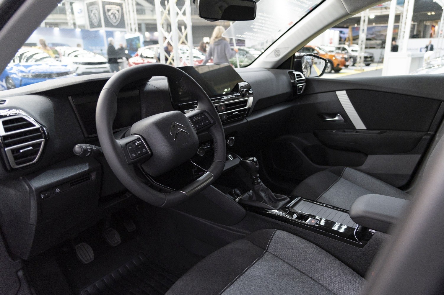 Dashboard and steering wheel close-up with center console and fabric seats