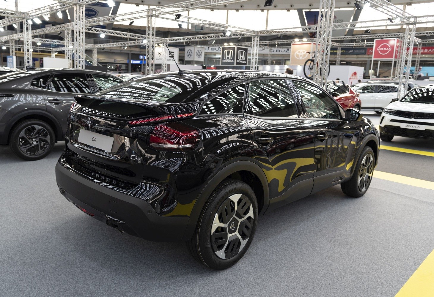 Rear-side view of black hatchback with unique taillights and alloy wheels