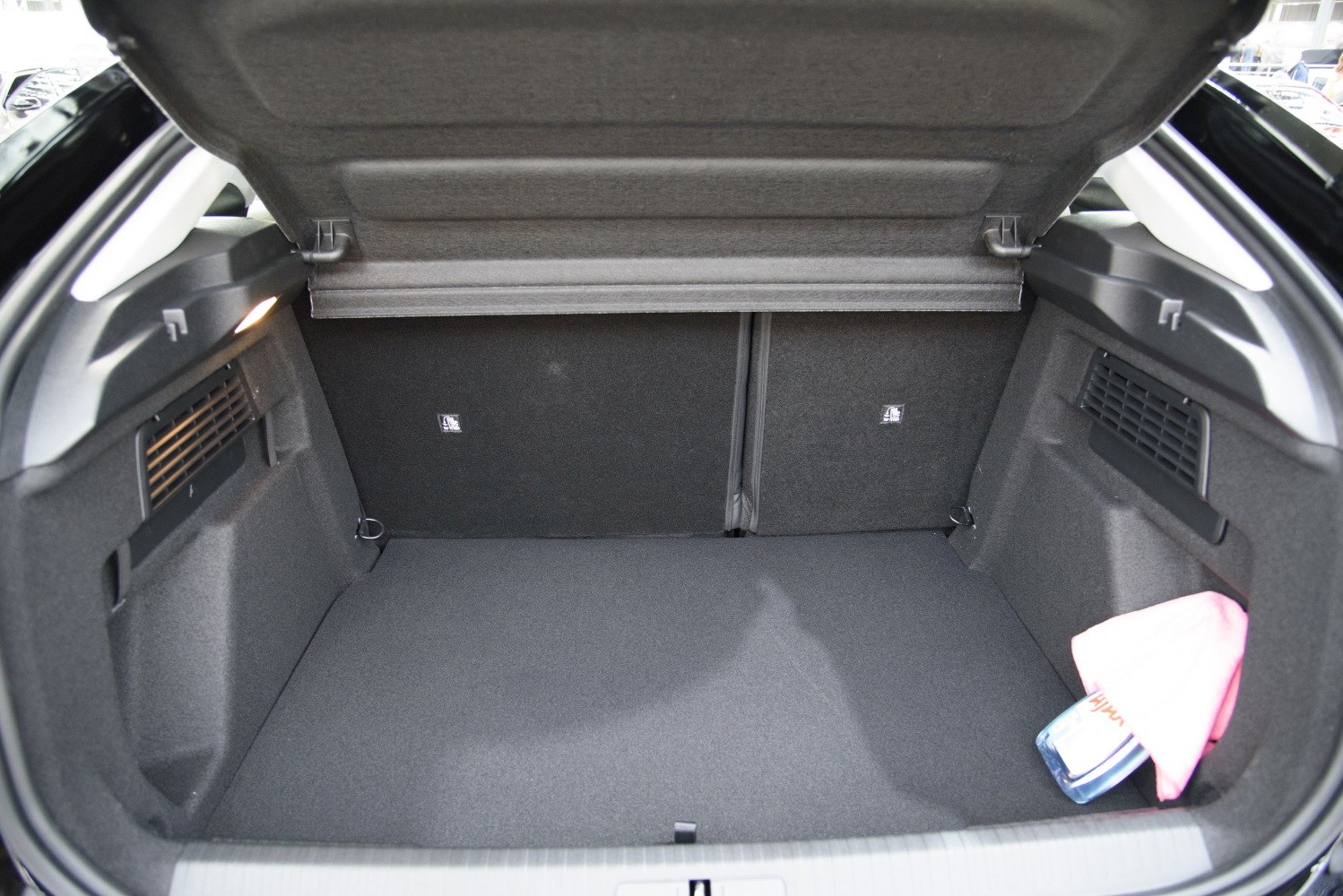 Spacious and organized car trunk interior with side compartments and a cargo cover.