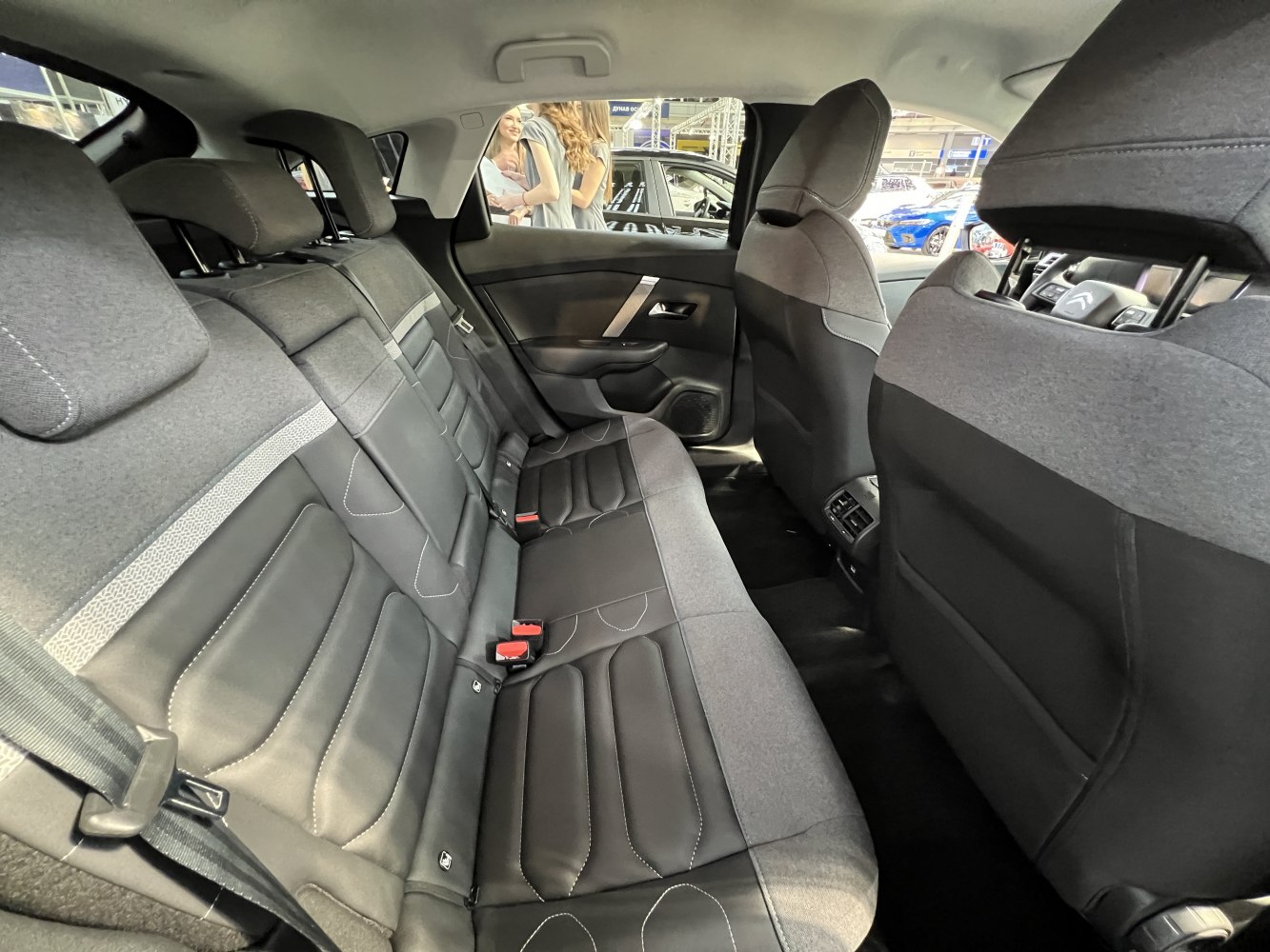 Rear seat interior with fabric and leather upholstery, detailed stitching