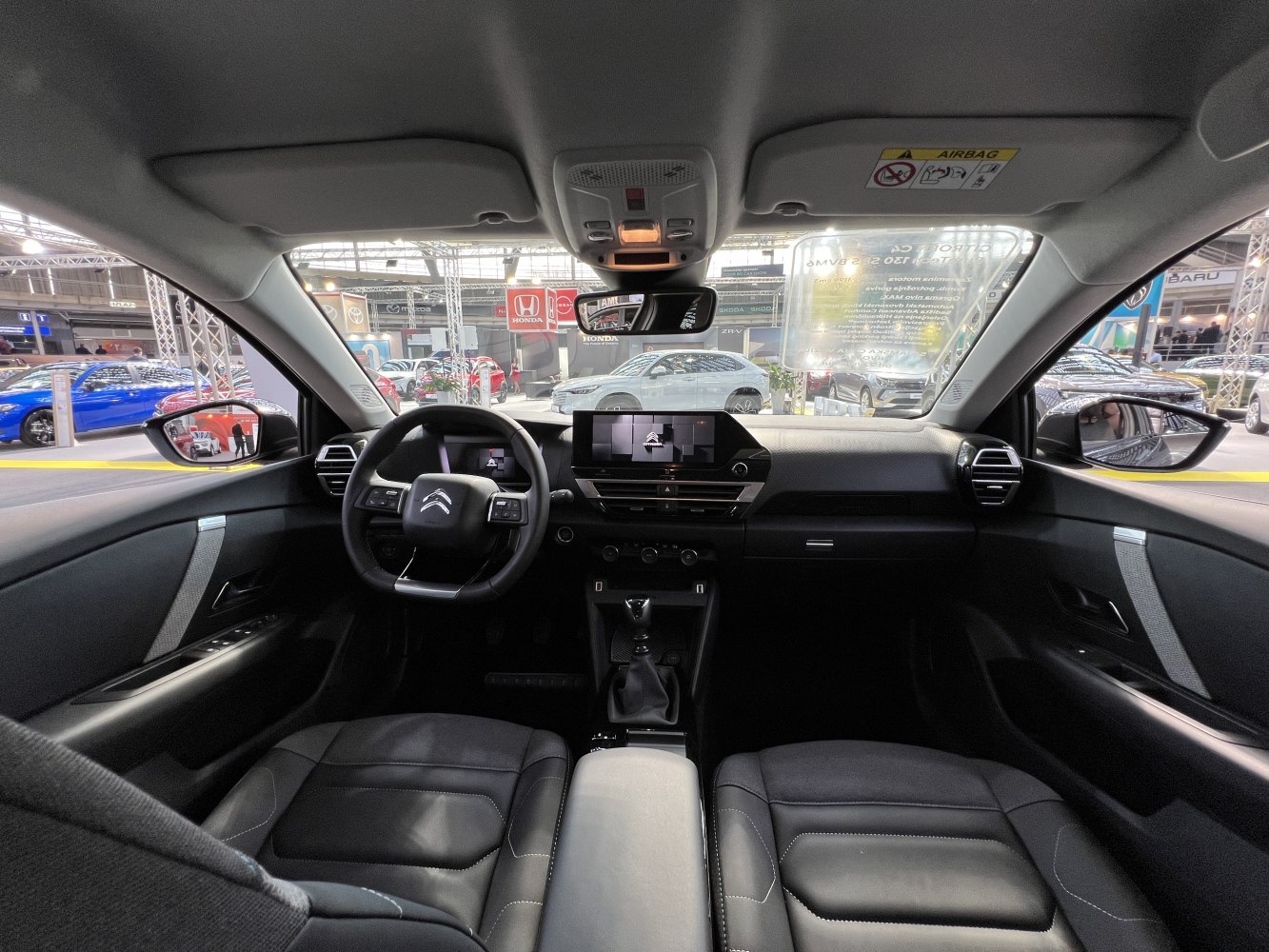 Interior view of modern dashboard with digital displays and manual gear lever