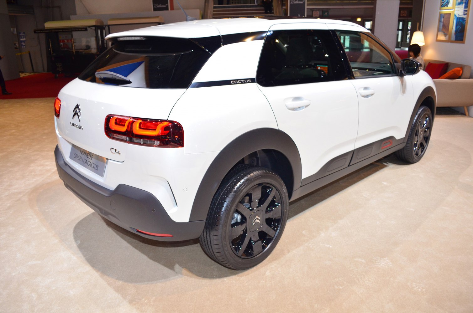 Rear view featuring distinctive taillights and black wheel rims on white compact SUV