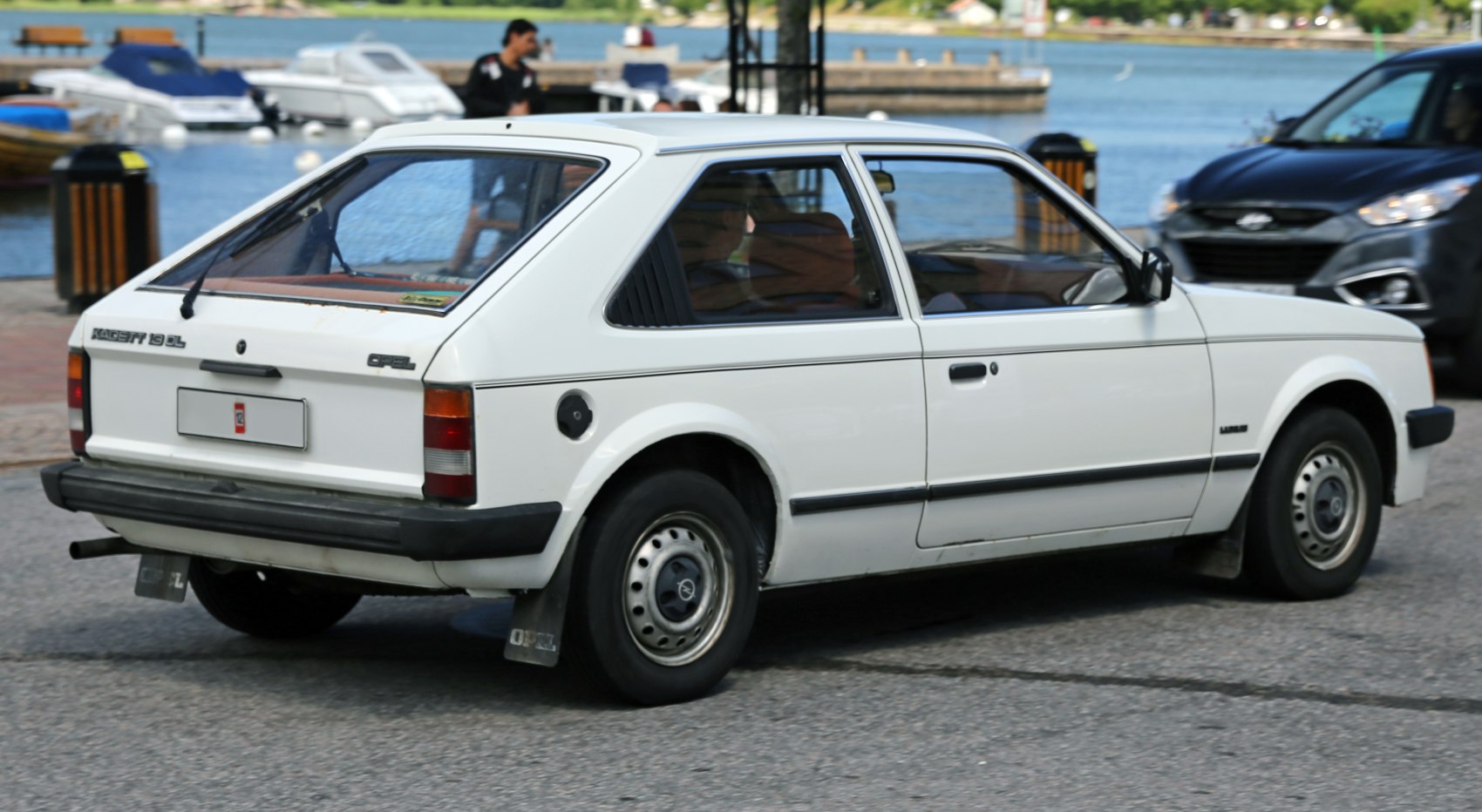 White angular hatchback rear side with rear wiper and steel wheels