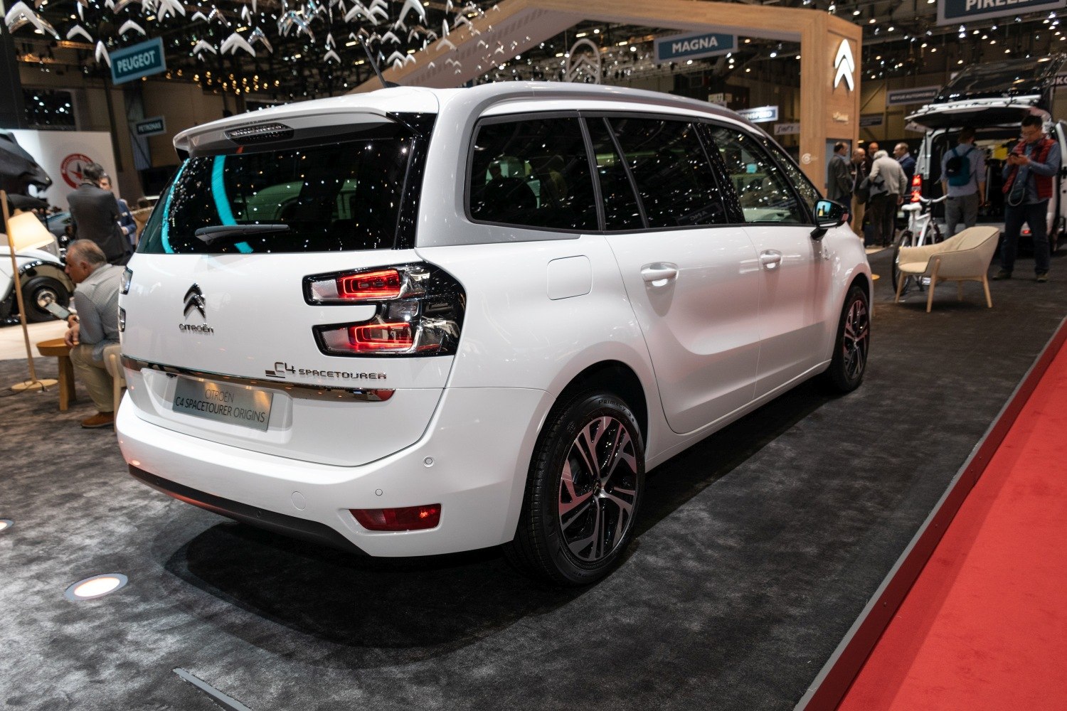 Rear view of a white spacious MPV with distinctive taillights