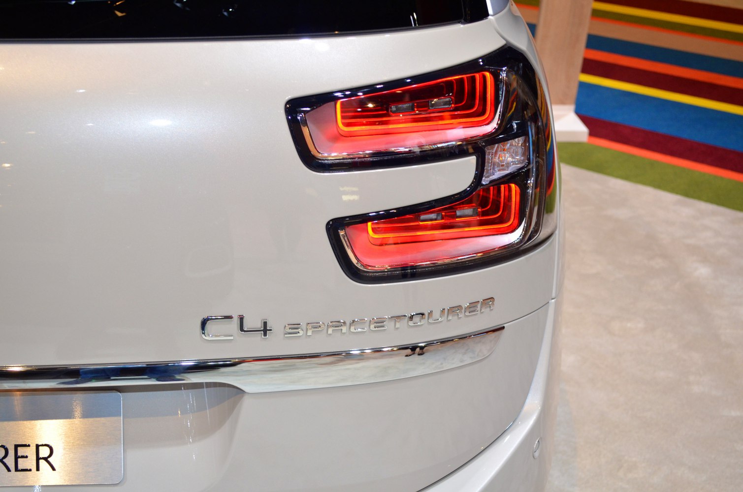 Close-up of LED rear taillight and logo emblem on vehicle rear.