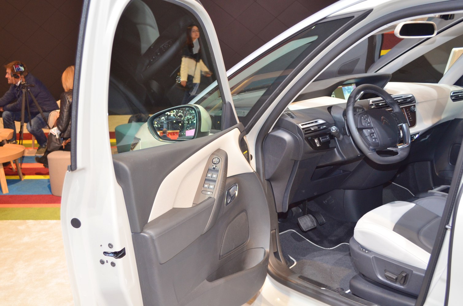Car interior door panel with controls and driver dashboard with steering wheel