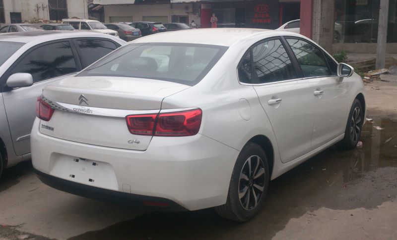 Rear side view with taillights and alloy wheels of white sedan