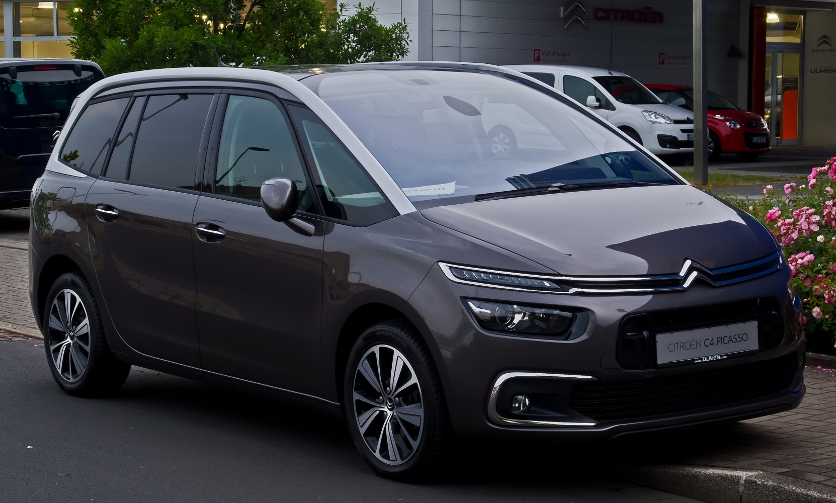 Front three-quarter view of a modern MPV with sleek headlights and aerodynamic design