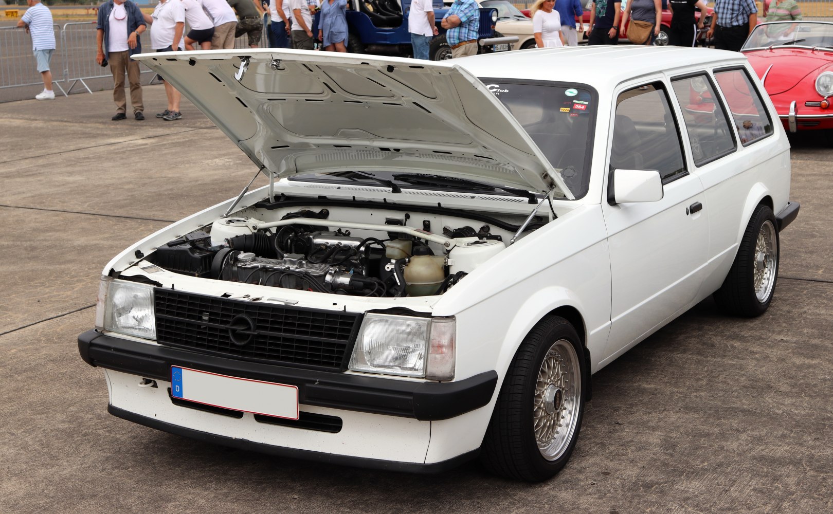 White classic station wagon with open hood revealing engine bay