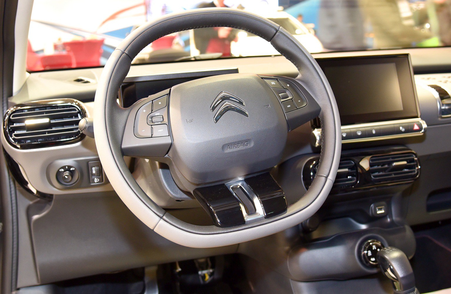 Steering wheel with controls and dashboard with infotainment screen