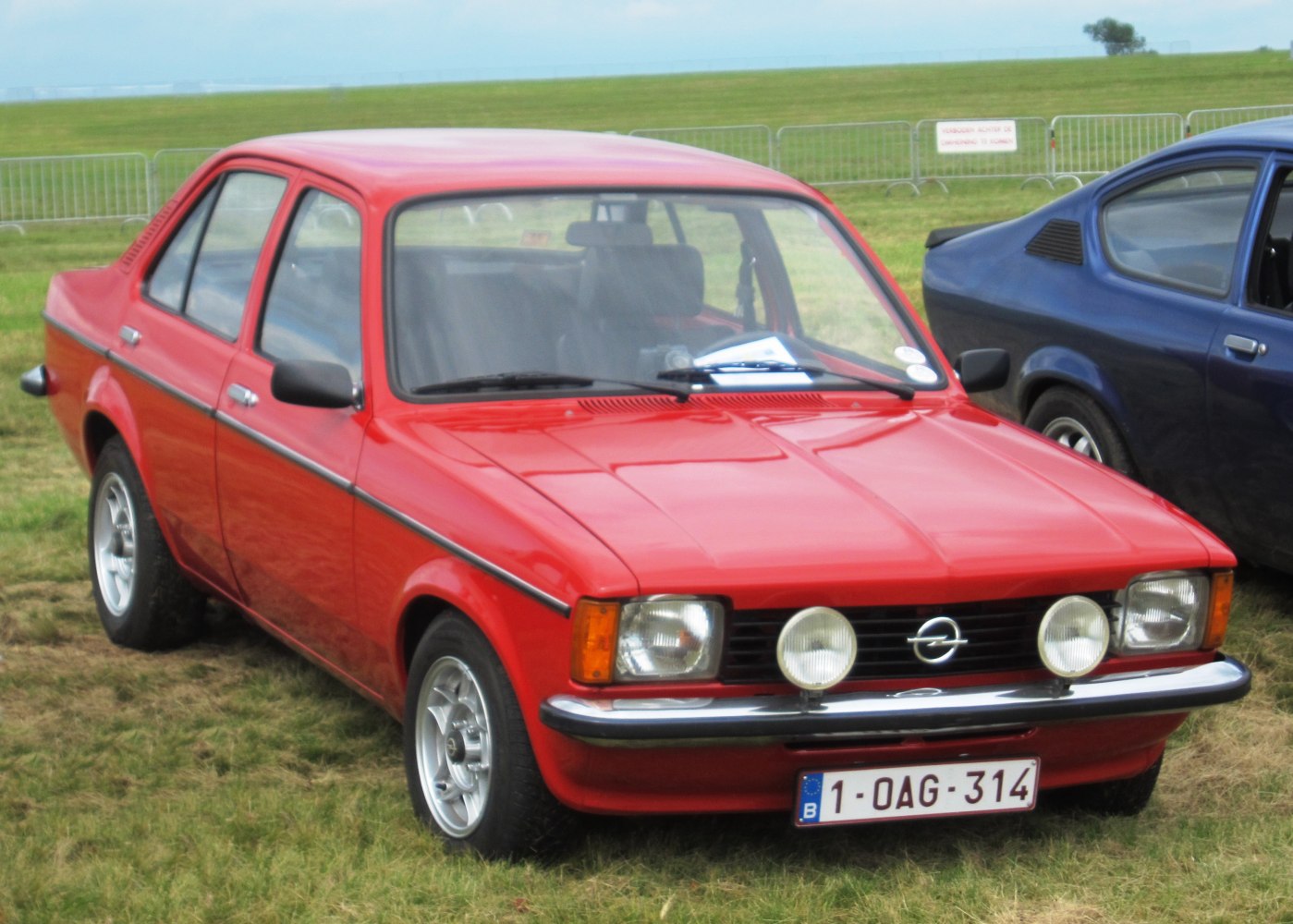 Red vintage sedan with round auxiliary lights and chrome bumper