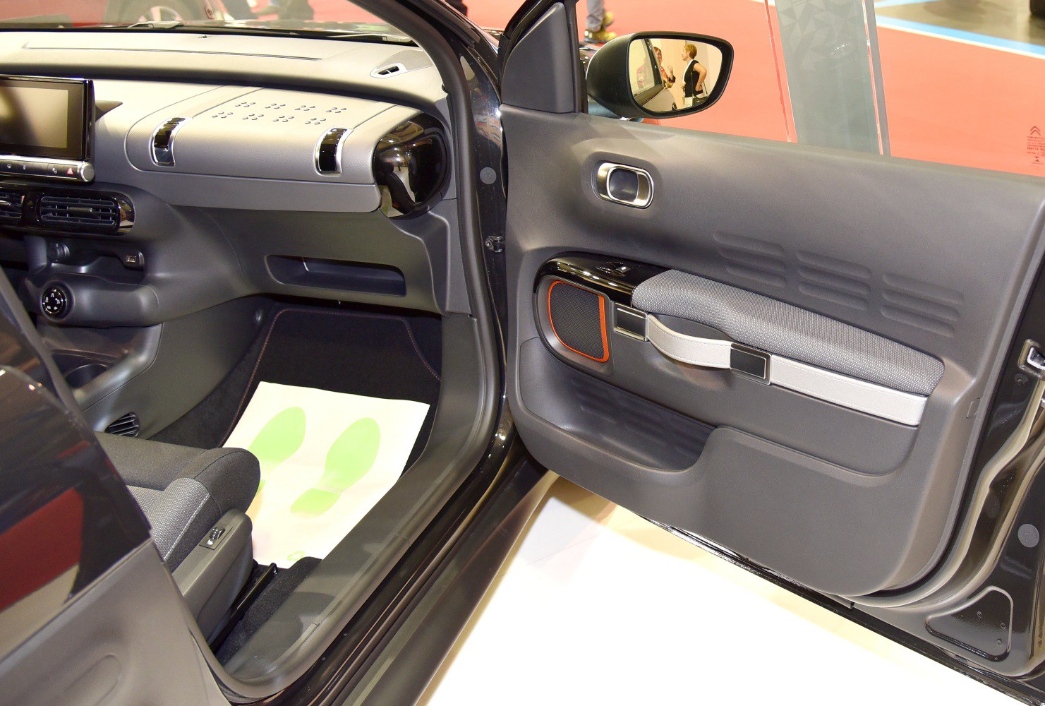 Interior door panel with integrated armrest and speaker, dashboard with air vents