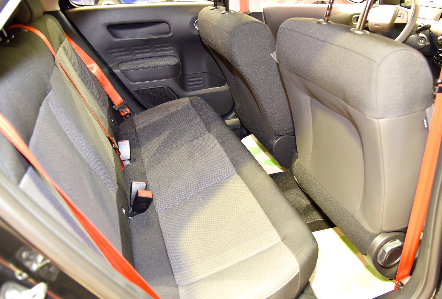 Rear seats and red seatbelts in compact car interior