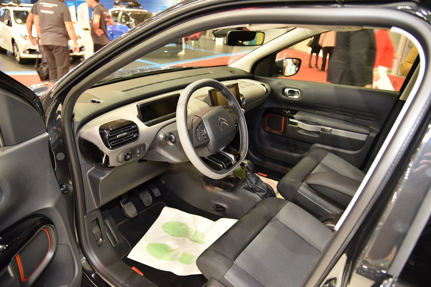 Steering wheel, dashboard, front seats, and interior design in a compact vehicle.
