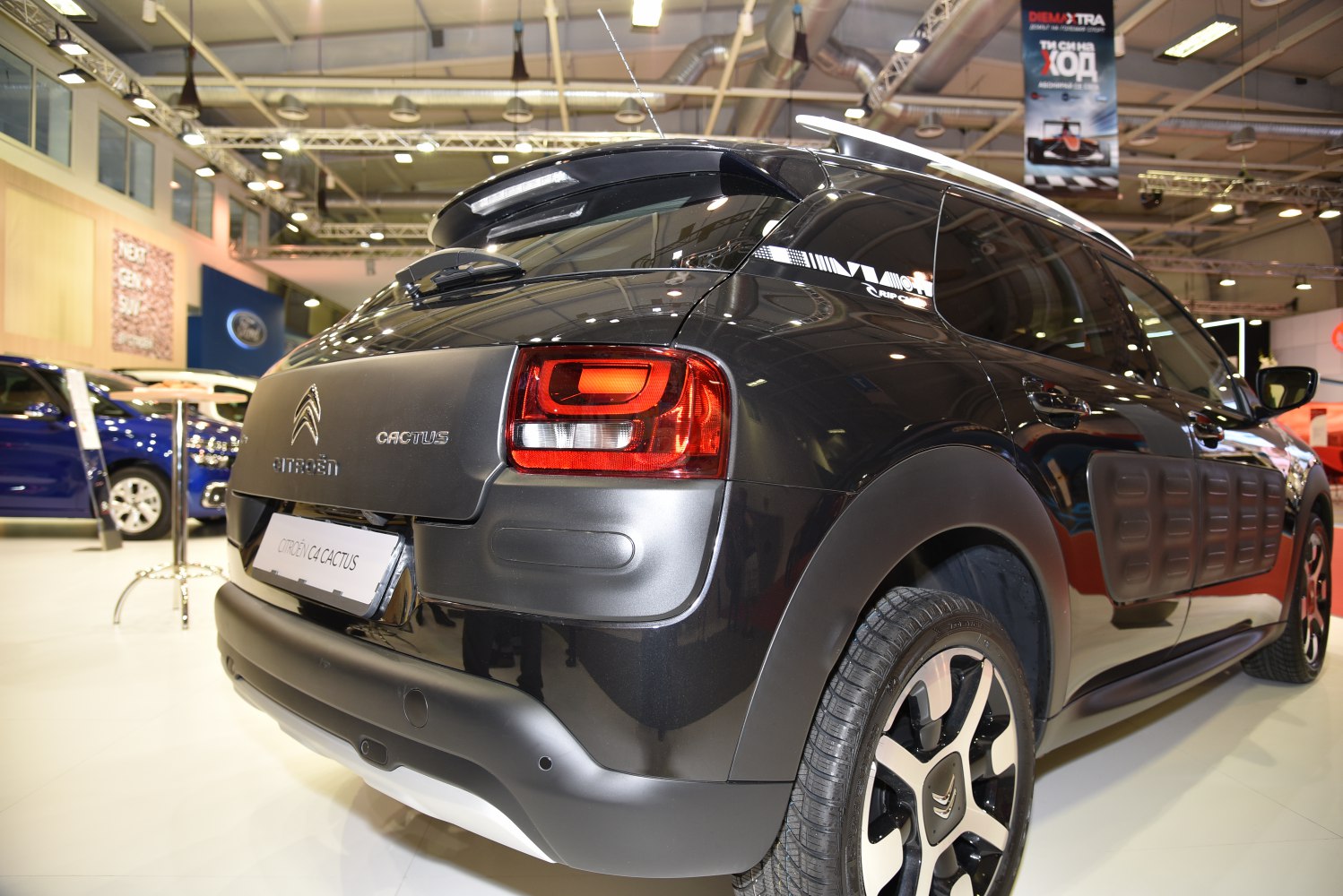 Rear view of a black vehicle with red taillights and textured side protective panels.