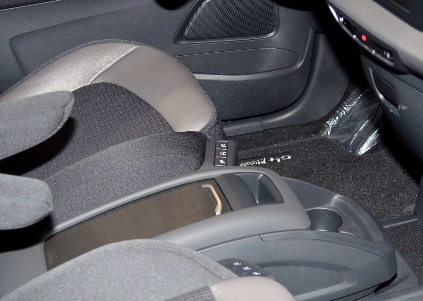 Interior view showing seat upholstery and center armrest with controls.