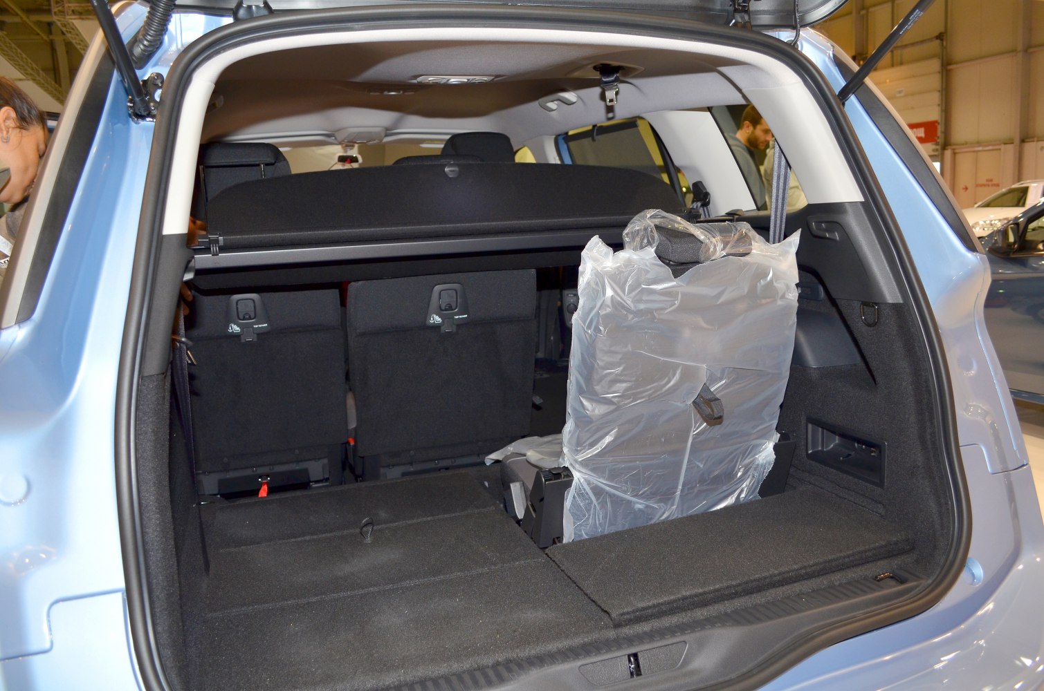 Open rear cargo space with folding seats and plastic-wrapped accessory