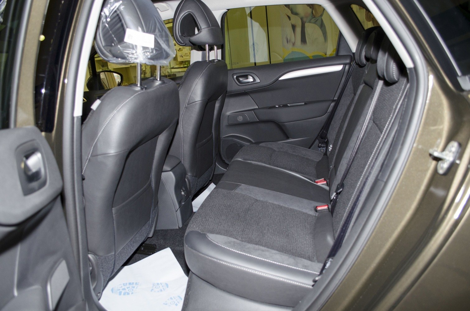 Rear passenger seats and door panel with black upholstery and headrests