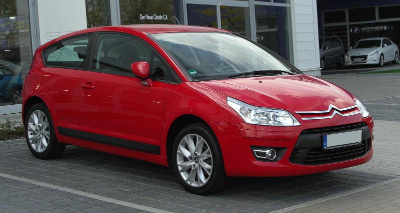 Red compact hatchback with alloy wheels and swept-back headlights