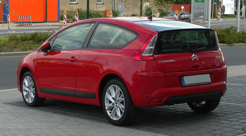 Rear and side view of a red hatchback with sporty coupe profile and distinctive rear window design