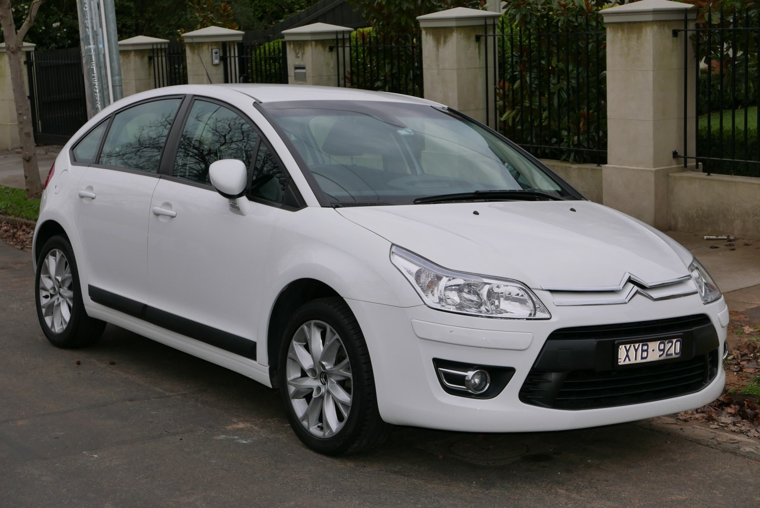 Front side view of white hatchback with distinctive headlights