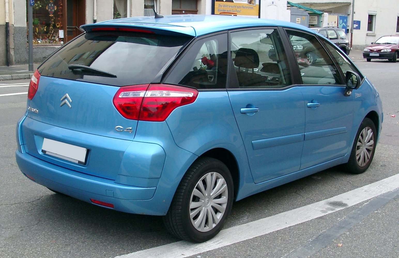 Rear-side view featuring tail lights and hatchback design of a compact MPV