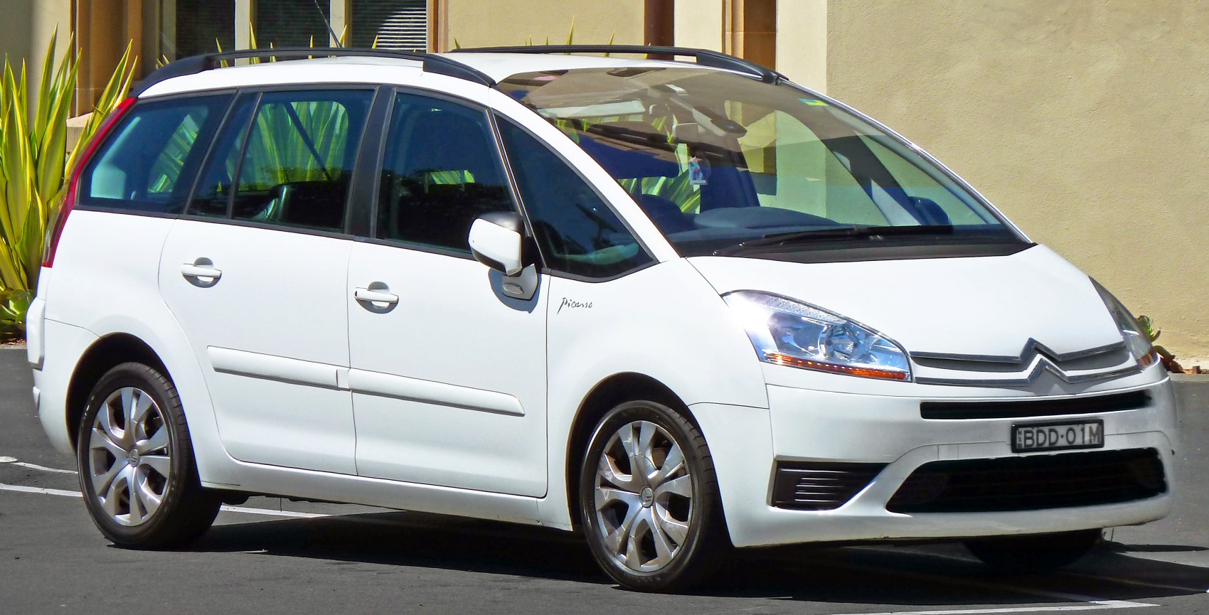 Front and side view of spacious MPV with distinctive headlights and roof rails