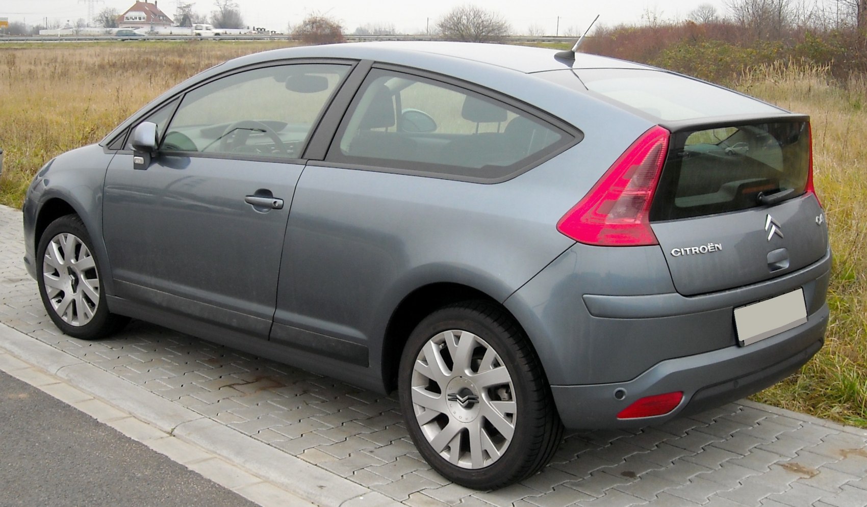 Rear and side view of a compact coupe with distinctive tail lights and alloy wheels