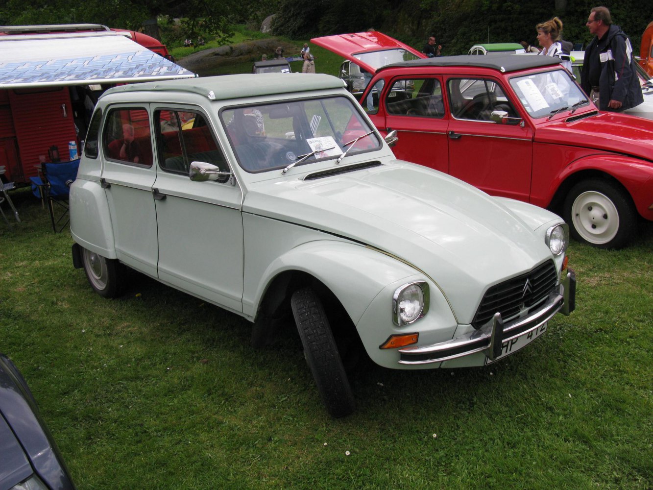 Compact vintage car with rounded headlights, hood vents, and chrome bumper guards.