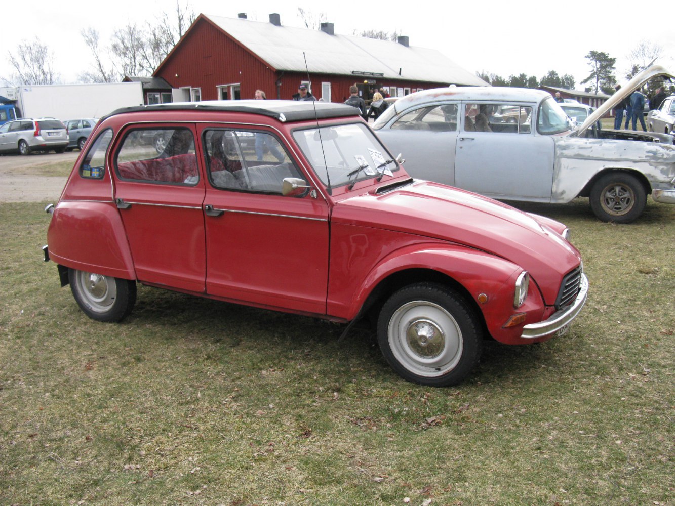 Red compact vintage car with rounded design and canvas sunroof