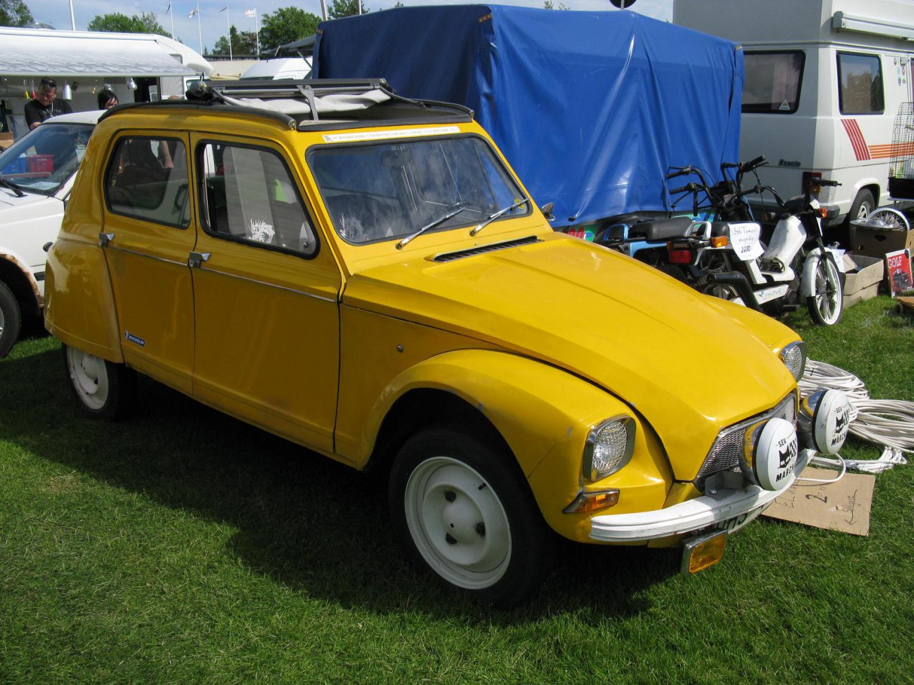 Yellow vintage hatchback with roof rack and dual fog lights