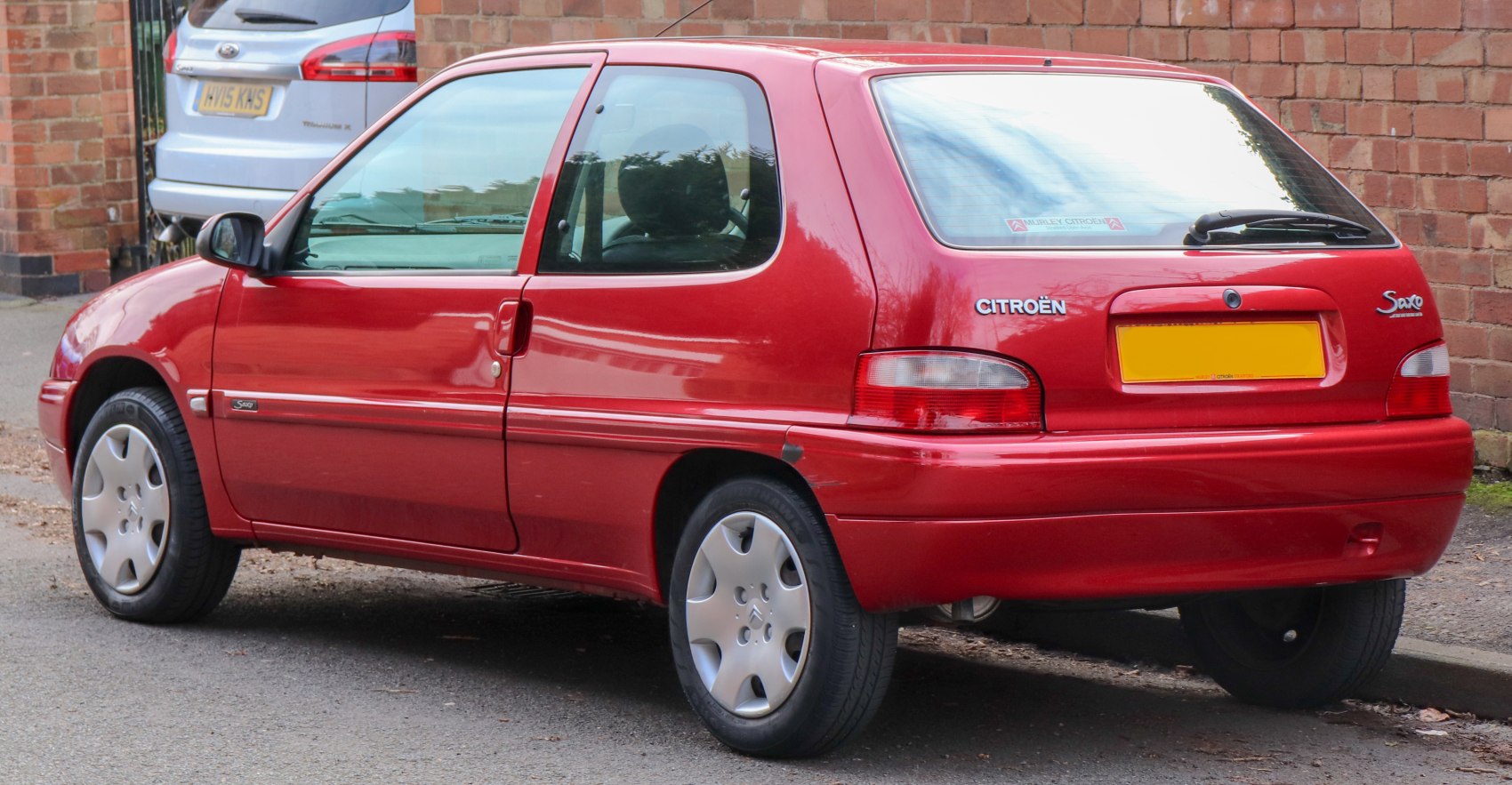 Rear side view of a red 3-door compact hatchback.