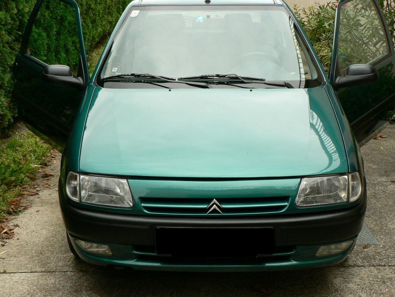 Front view of compact hatchback with open front doors and rectangular headlights