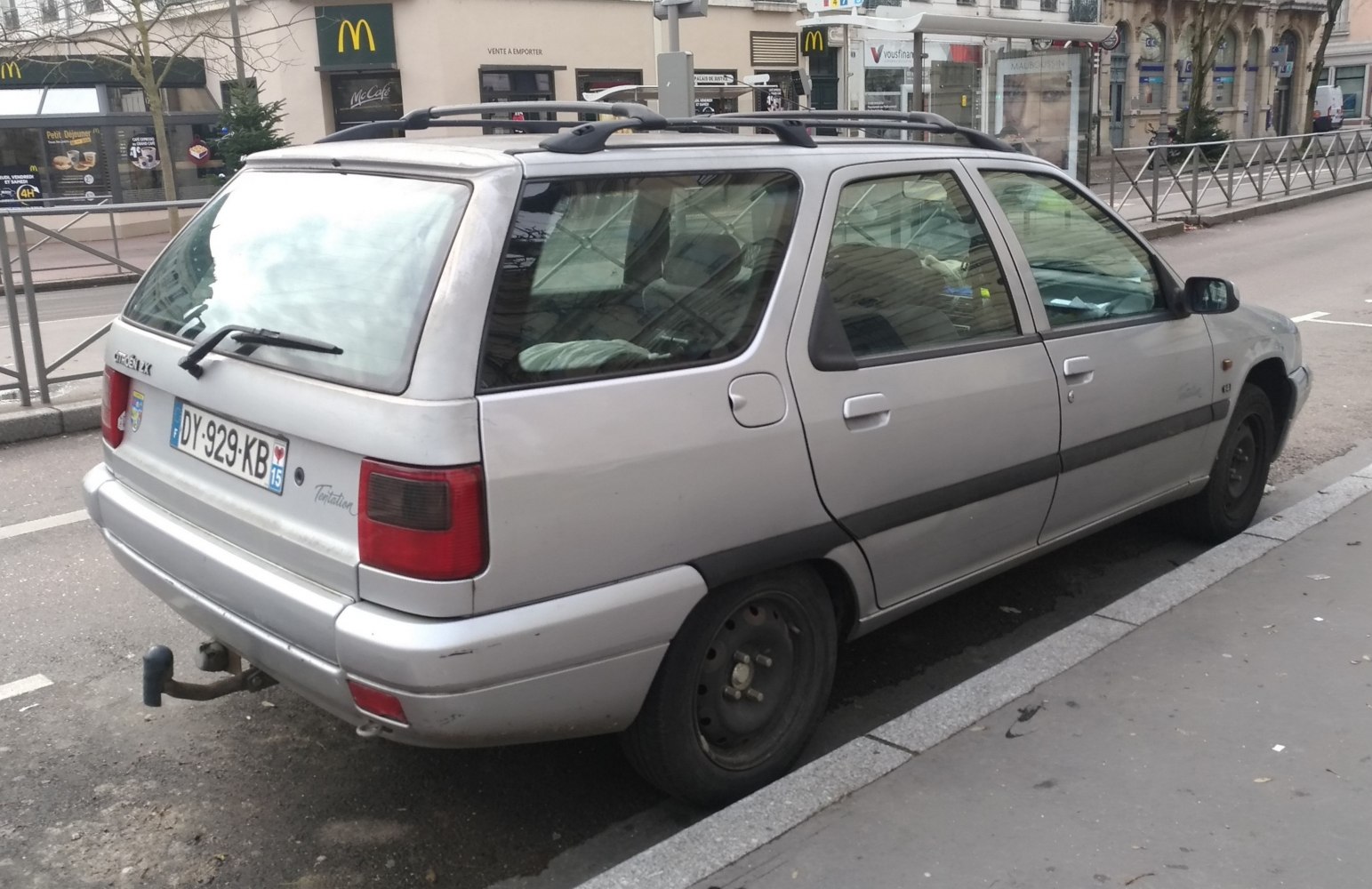 Rear side view of a 1990s station wagon with roof rails and tow hitch