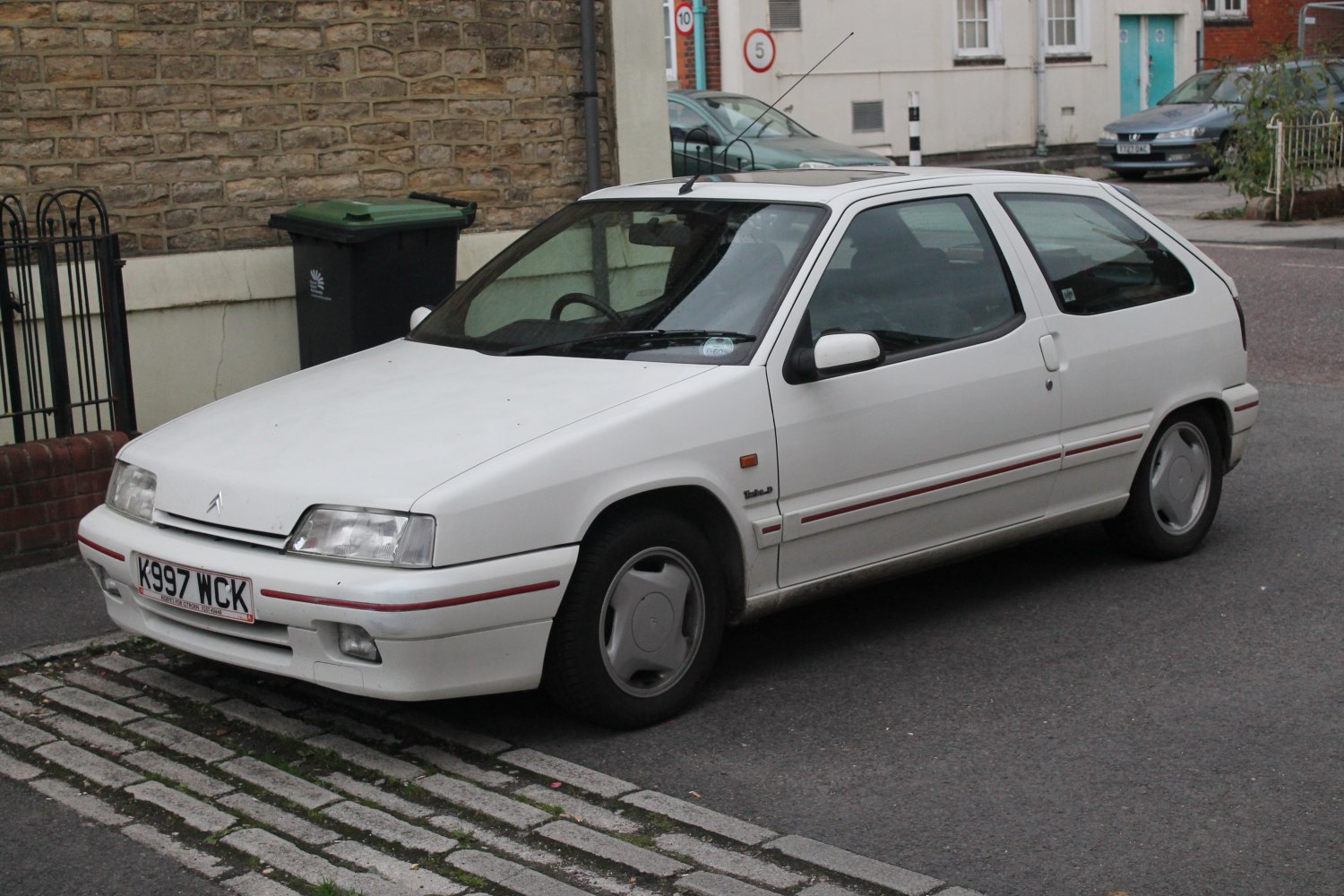 White 3-door hatchback with red stripe and aerodynamic shape
