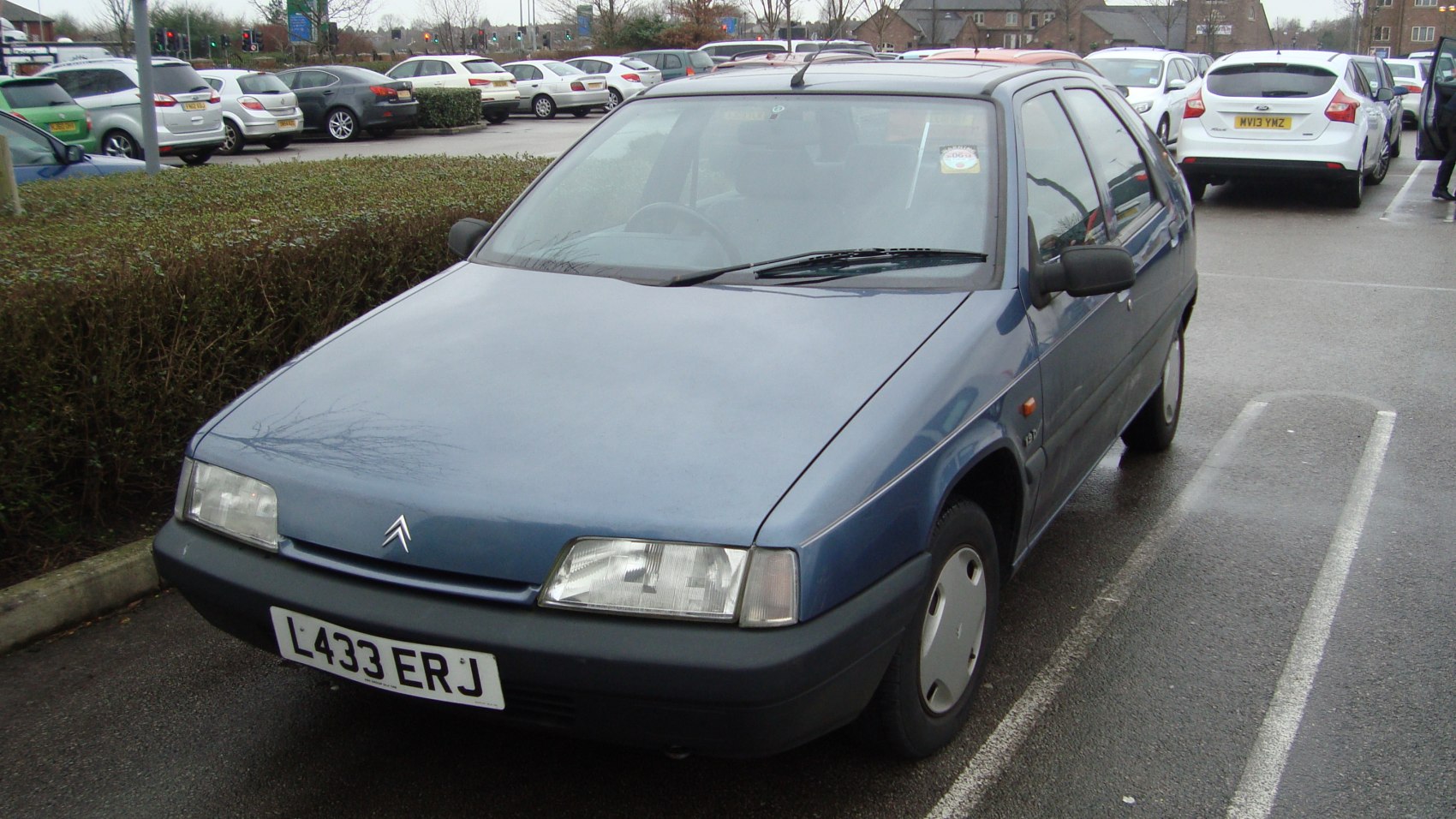 Front and side profile of a classic 5-door hatchback with rectangular headlights and simple wheel covers.