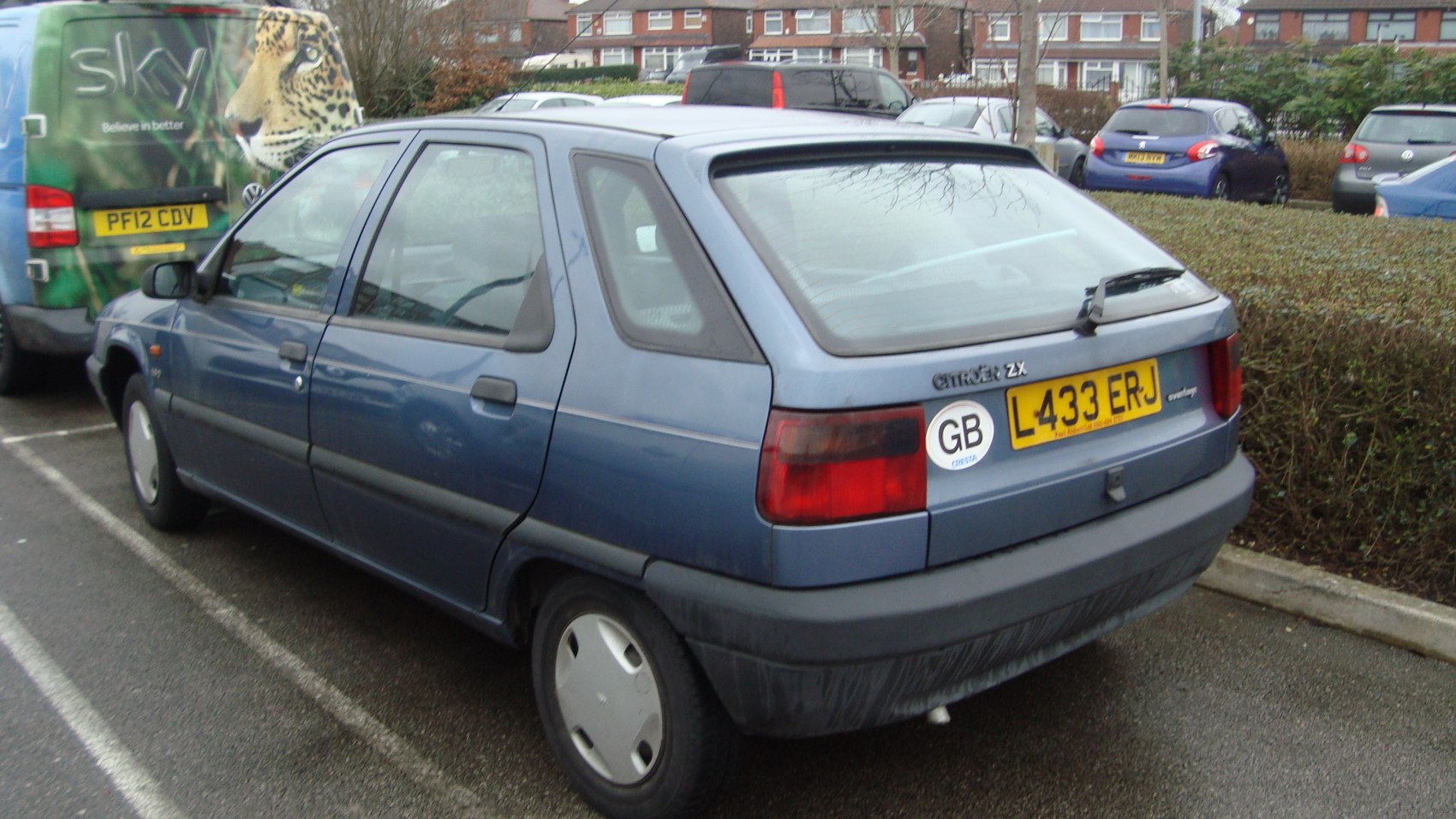 Rear and side view of a blue 5-door hatchback with distinct tail lights.