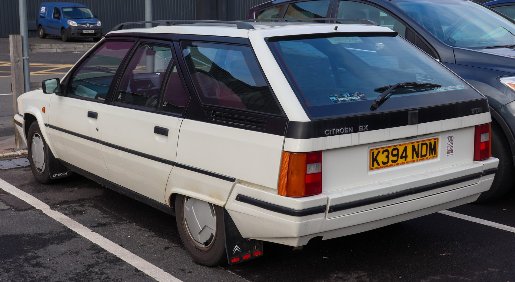 Rear and side view of white angular hatchback with hatchback rear window and mud flaps
