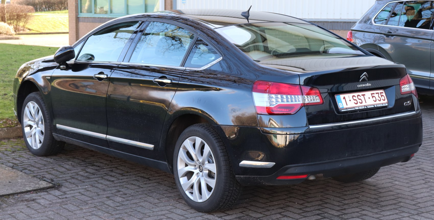 Black sedan rear side with alloy wheels and taillights