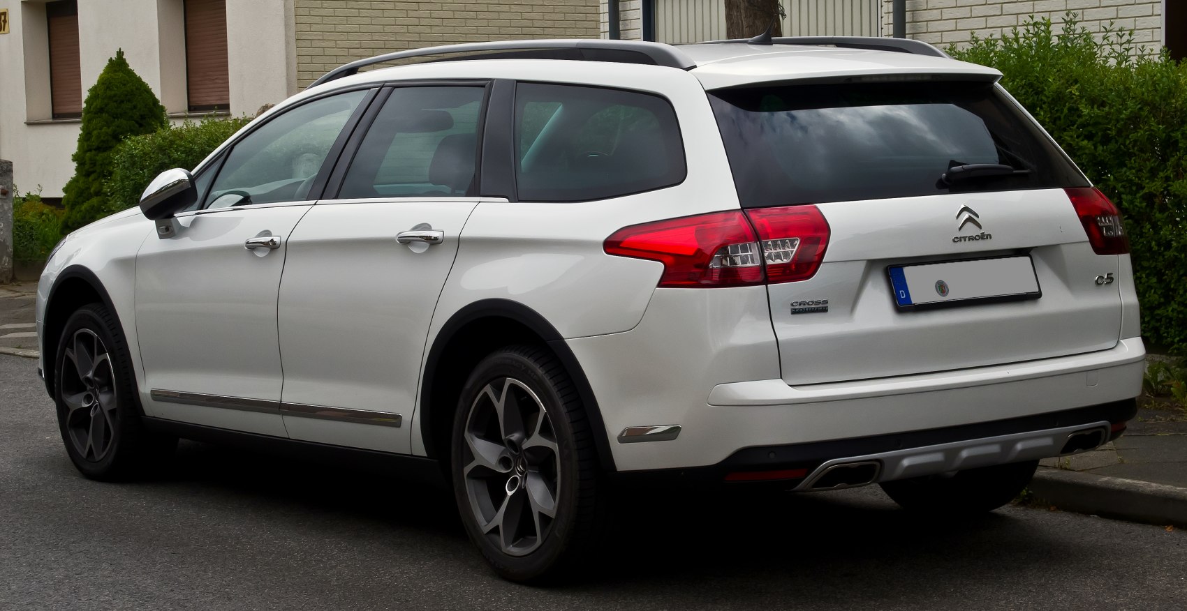 White station wagon with roof rails and modern rear lights