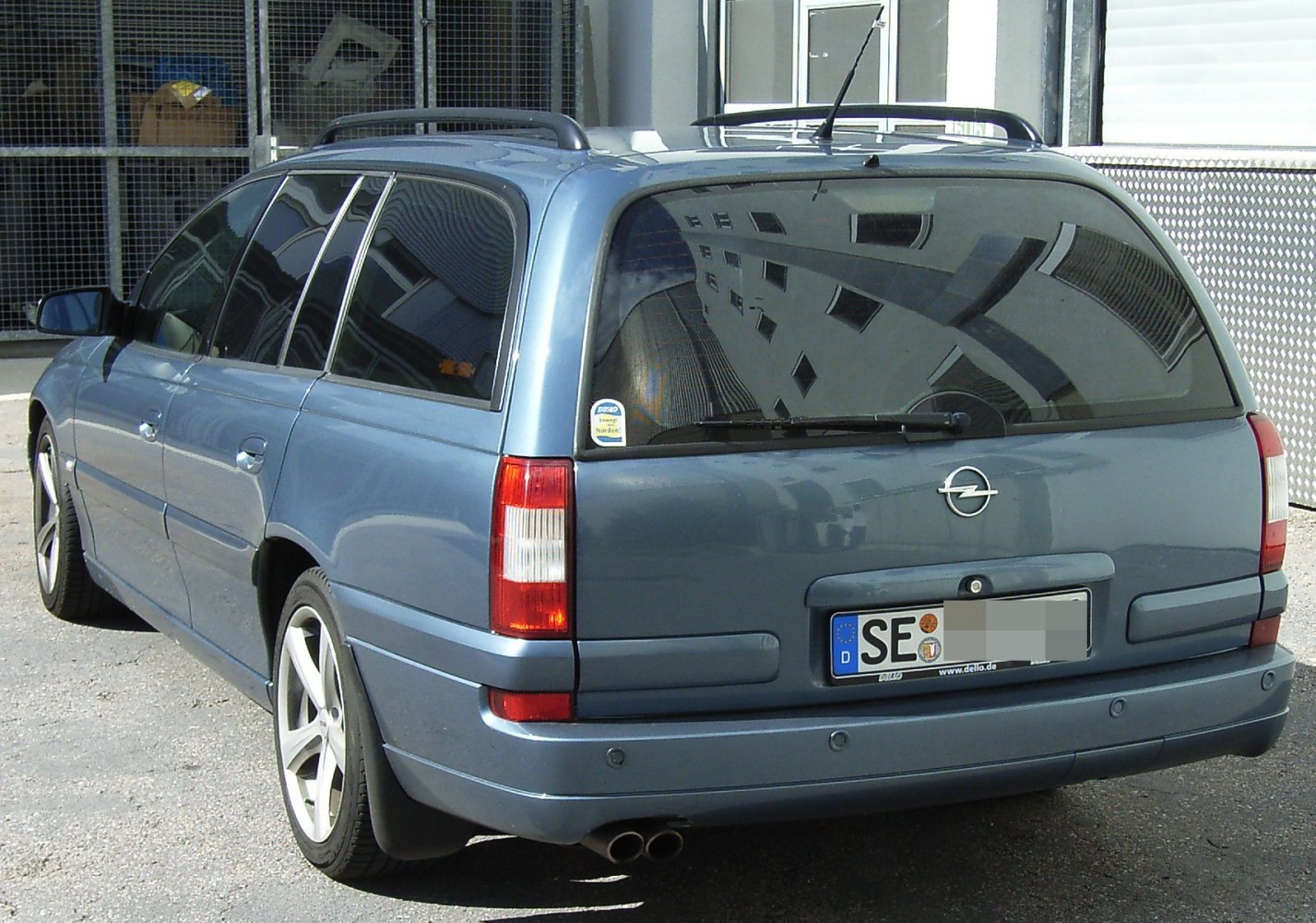 Rear view of a facelifted Omega B Caravan estate with roof rails and dual exhaust