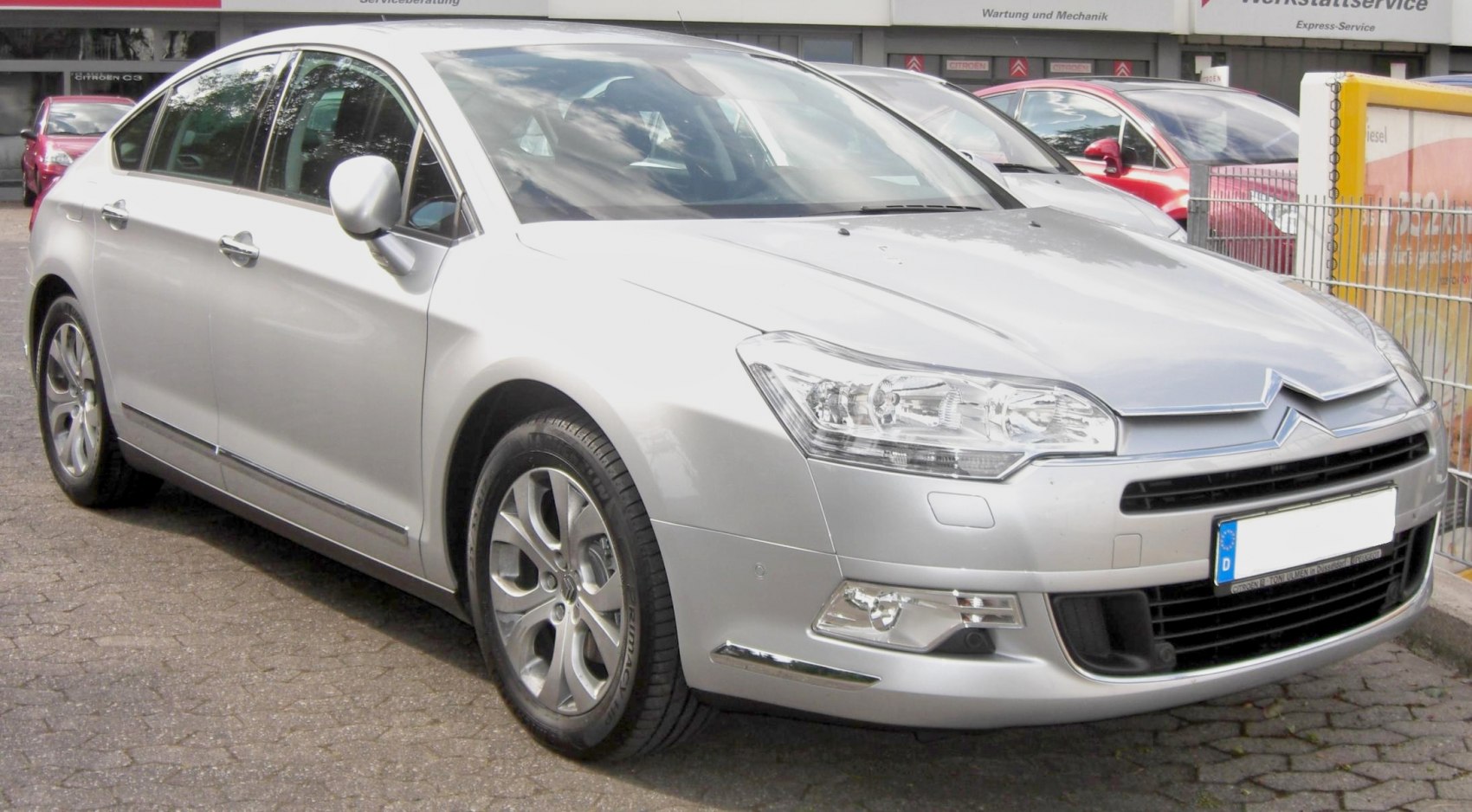 Front-side view of silver sedan with alloy wheels and modern headlights