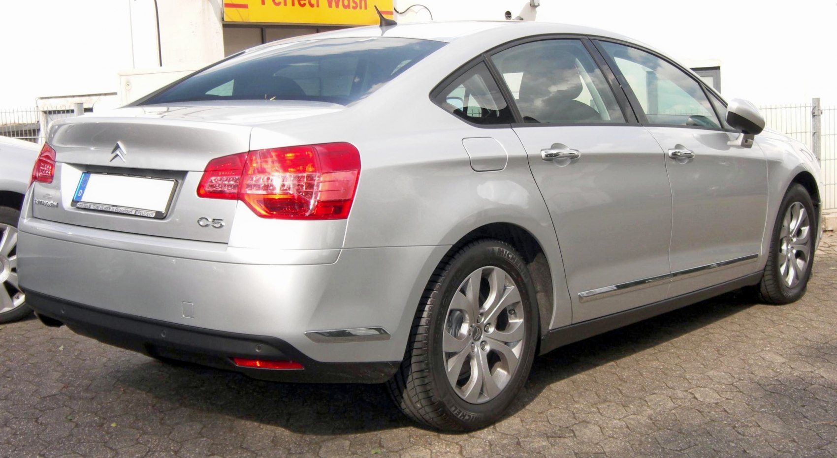 Rear side of sedan with alloy wheels and taillights