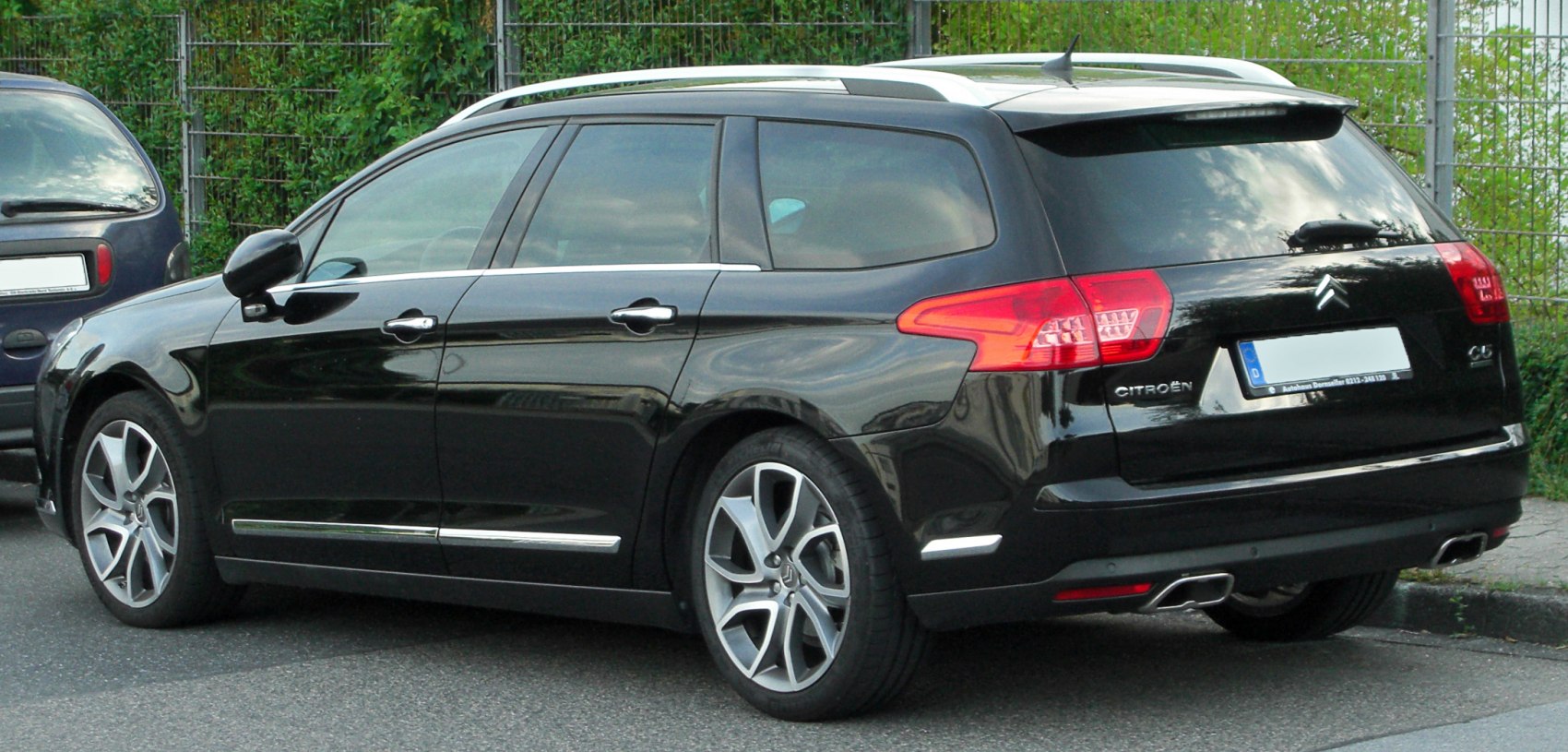 Rear side view of black station wagon with alloy wheels
